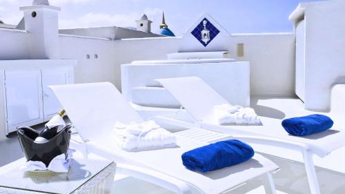Royal Villa Alegria في لا أوليفا: كرسيان أبيض عليهما وسائد زرقاء في غرفة