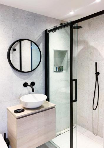 a bathroom with a sink and a shower at The Lookout in Swanage