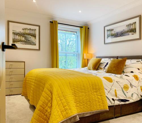 um quarto com uma cama com um cobertor amarelo em The Lookout em Swanage