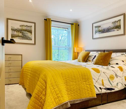 a bedroom with a bed with a yellow blanket at The Lookout in Swanage