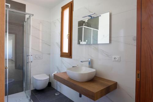 a white bathroom with a sink and a toilet at AGRITURISMO DA LAURA in Povoletto