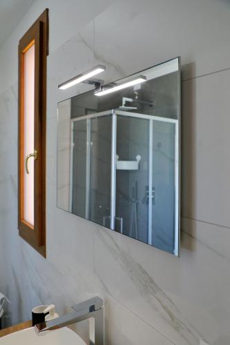 a mirror on a wall above a sink in a bathroom at AGRITURISMO DA LAURA in Povoletto