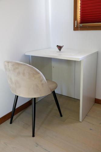 a white desk with a chair next to a table at AGRITURISMO DA LAURA in Povoletto
