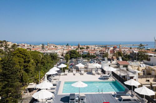 a view of a pool with umbrellas and a city at Jo An Palace in Rethymno Town