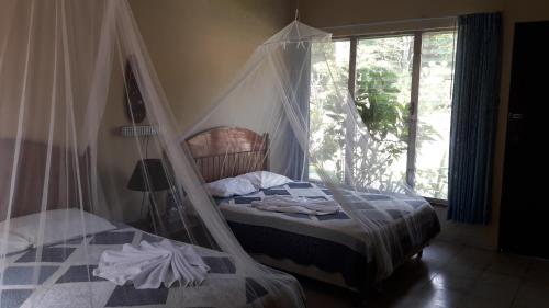 a bedroom with a bed with a mosquito net at Hotel Tikal Inn in Tikal
