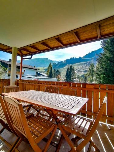 a wooden table and chairs on a deck with a view at Appartement Bel Monte in Bad Kleinkirchheim