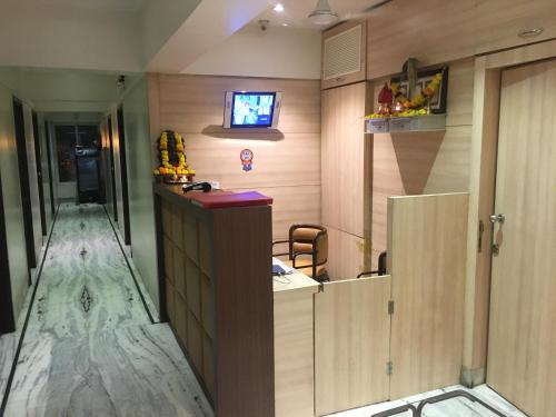 a room with a counter and a tv on a wall at Pravasi Residency in Thane