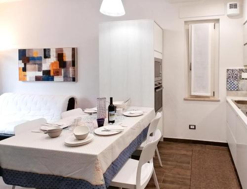 a white dining room with a table and white chairs at Civico 62 - Case Vacanza D Andrea in Pratola Peligna