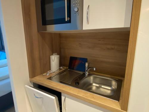 eine Küche mit Spüle und Mikrowelle in der Unterkunft Haus am See Luxury HS 223 B in Hahnenklee-Bockswiese