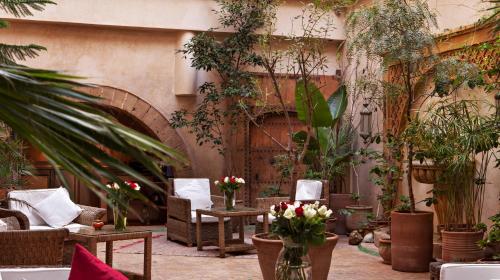 a patio with chairs and plants in a courtyard at Riad Chbanate in Essaouira