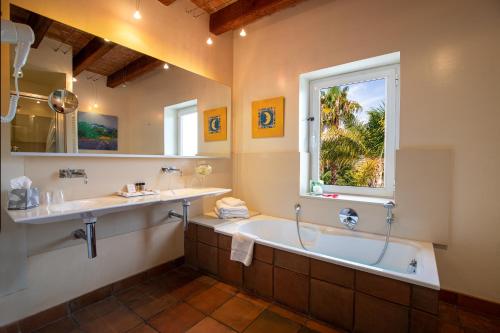 a bathroom with a tub and a sink and a window at Tancat de Codorniu in Les Cases d'Alcanar