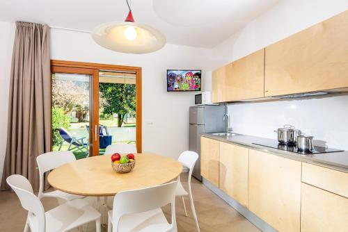 a kitchen and dining room with a table and chairs at Villaggio Los Nidos in Lignano Sabbiadoro