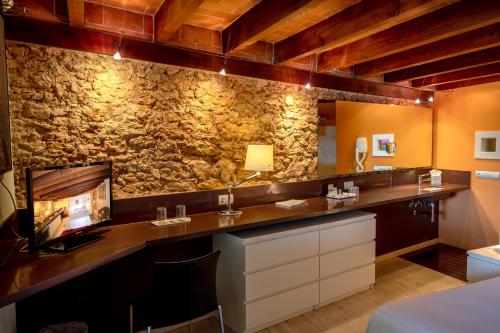 a bar in a room with a stone wall at Tancat de Codorniu in Les Cases d'Alcanar