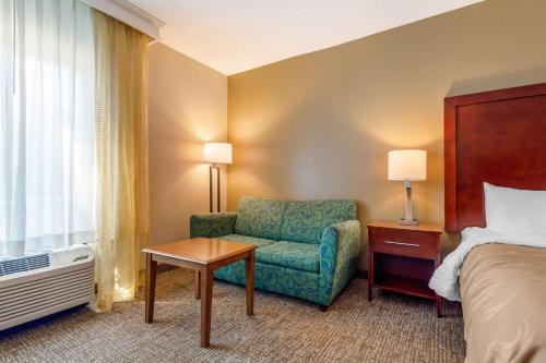 a hotel room with a bed and a chair at Quality Inn & Suites Olde Town in Portsmouth