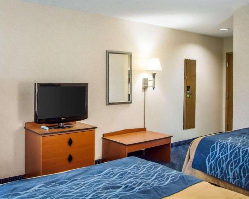 a hotel room with a bed and a flat screen tv at Comfort Inn in Piketon