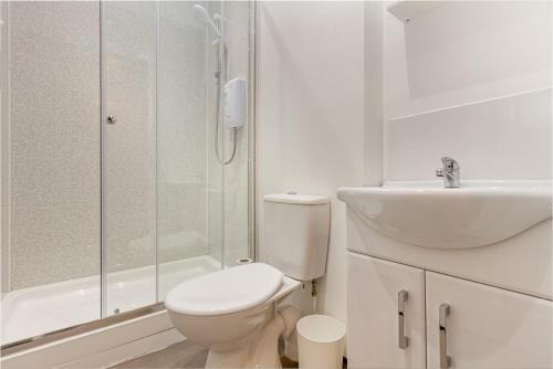 a white bathroom with a toilet and a sink at Guest Homes - The Foregate in Worcester