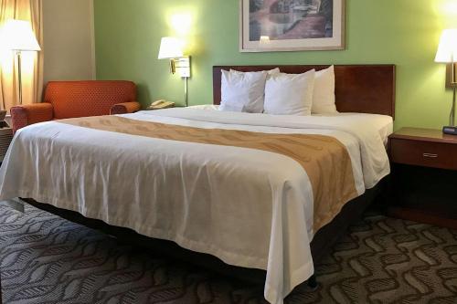 Holland的住宿－赫蘭德品質酒店，酒店客房带一张大床和一把椅子