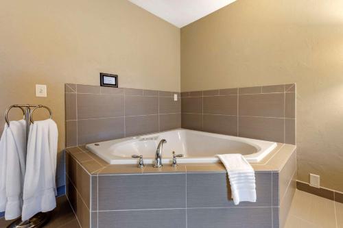 a bathroom with a tub with towels on a wall at Quality Inn in Dover