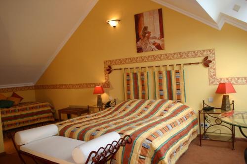 a bedroom with a large bed and a table at Hotel Le Relais de Pommard in Francorchamps