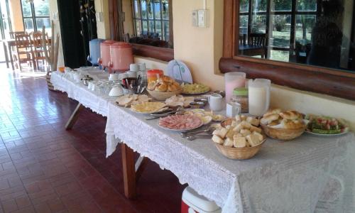 ein langer Tisch mit vielen Teller Essen drauf in der Unterkunft Casa de campo La Querencia in Villa Cura Brochero
