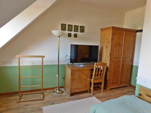 a bedroom with a bed and a desk with a television at Berki Vendéglő és Hotel in Körmend