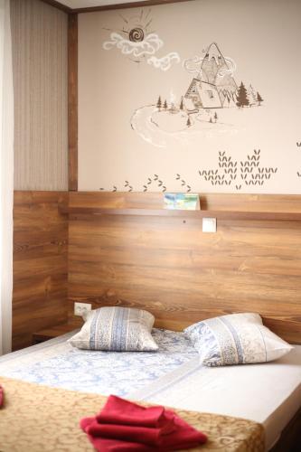 a bedroom with a bed with a wooden head board at Туристичний комплекс ВОРОХТА 365 Turistichesky Kompleks Vorokhta 365 in Vorokhta