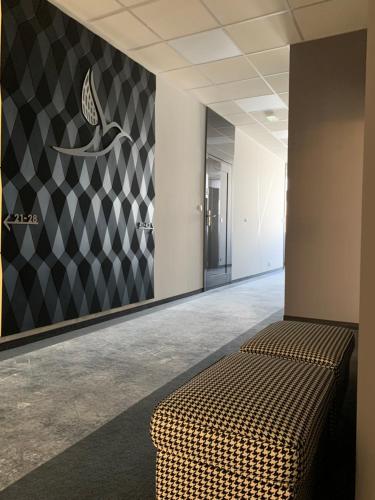 a room with a couch and a wall with a checkered wall at Hotel Coliber in Kłobuck