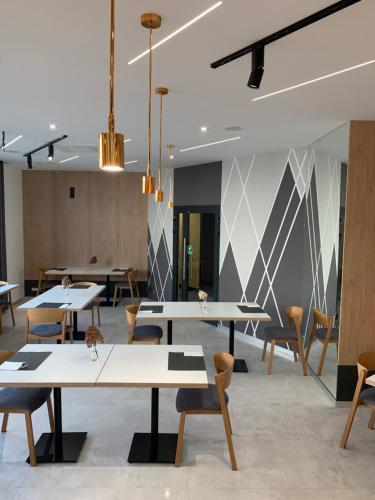 a dining room with tables and chairs and a wall at Hotel Coliber in Kłobuck
