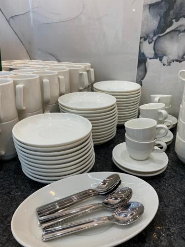 a table with white plates and silverware on it at Hotel Coliber in Kłobuck