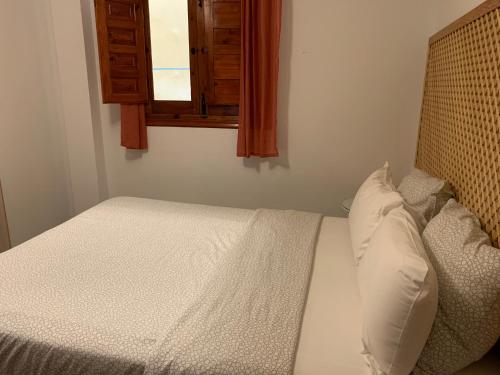 een kleine slaapkamer met een bed en een raam bij AnDiMi Pozo Chico in Toledo