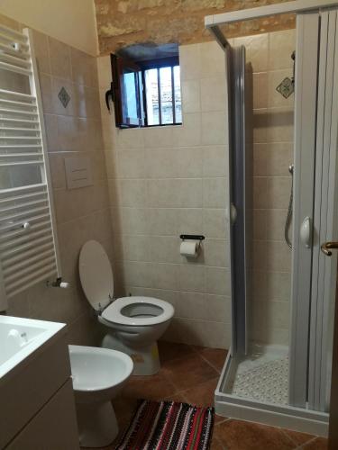 y baño con aseo, lavabo y ducha. en Guado di Pio- monolocale, en Il Guasto