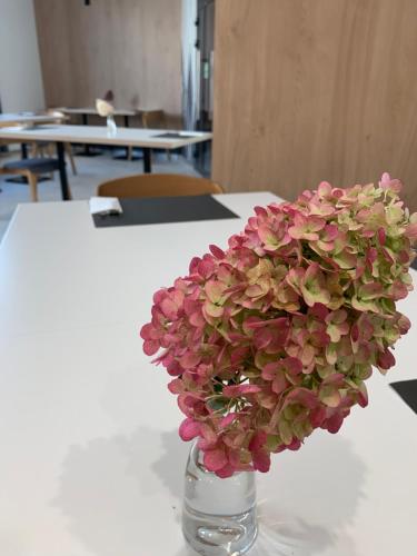 a vase filled with pink flowers sitting on a table at Hotel Coliber in Kłobuck