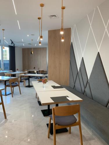 a dining room with tables and chairs and a wall at Hotel Coliber in Kłobuck