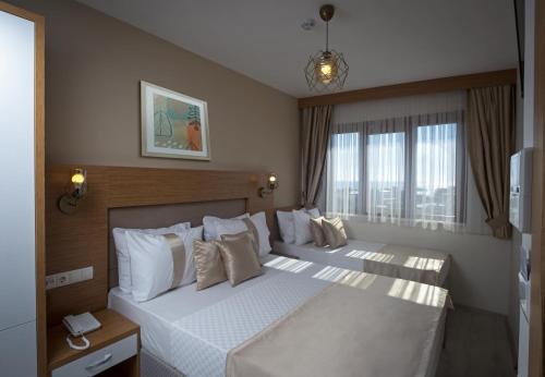 a bedroom with two beds and a large window at Zeyn Otel Istanbul in Istanbul