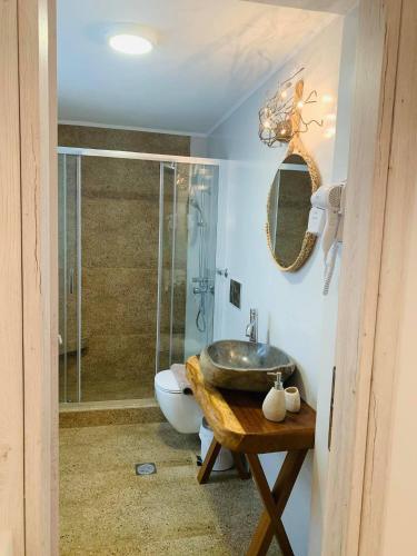 a bathroom with a sink and a shower at Semiramis Guesthouse in Adamas