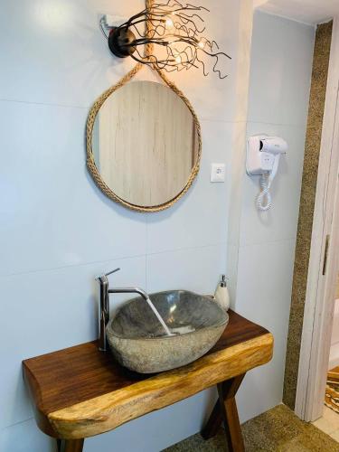 a bathroom with a stone sink and a mirror at Semiramis Guesthouse in Adamas