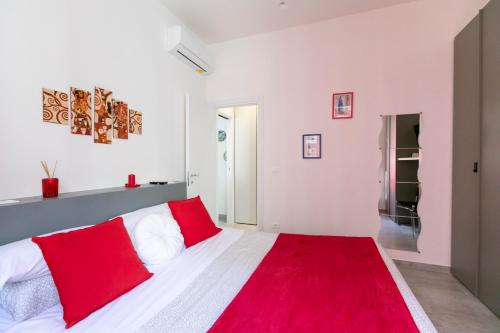 a bedroom with a bed with red and white pillows at Marconi Dreams in Bologna