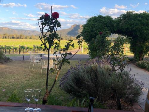 a table with two wine glasses and a flower on it at Nightingale Villas in Broke