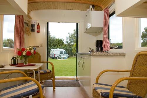 een keuken en eetkamer met een tafel en stoelen bij Camping 't Bosch in Zelhem