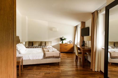 a hotel room with a bed and a desk and a bedroom at Aqua Montis Resort & Spa in Rivisondoli