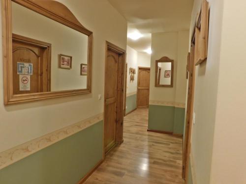 a hallway with a mirror on the wall and a door at Berki Vendéglő és Hotel in Körmend