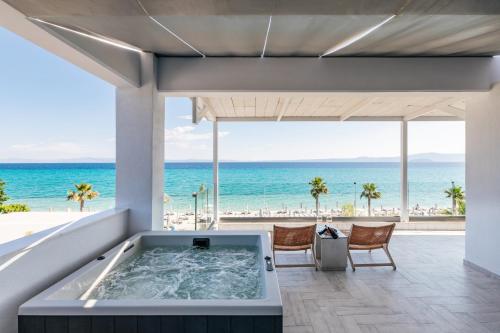 a hot tub with the ocean in the background at Blue Carpet Luxury Suites in Pefkohori
