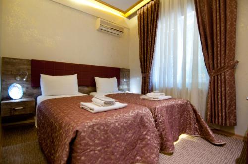 Ένα ή περισσότερα κρεβάτια σε δωμάτιο στο Grand Ambiance Hotel