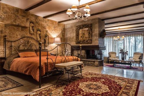a bedroom with a large bed and a fireplace at Vathyskia Guesthouse in Kato Trikala Korinthias