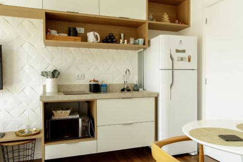 a kitchen with white cabinets and a white refrigerator at O Melhor do Alto da XV com garagem e sacada in Curitiba