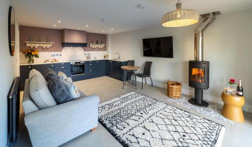 a living room with a couch and a stove at Hoglet Cottage in Carlisle