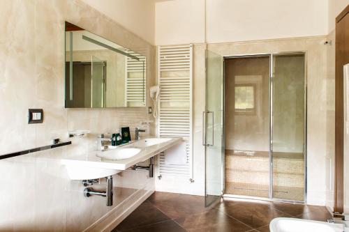 a bathroom with two sinks and a shower at Aqua Montis Resort & Spa in Rivisondoli