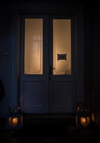 a door in a dark room with two candles in front at La Cles Deluxe Suites in Cles