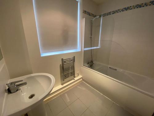 a white bathroom with a sink and a shower at Little Church Street in Rugby