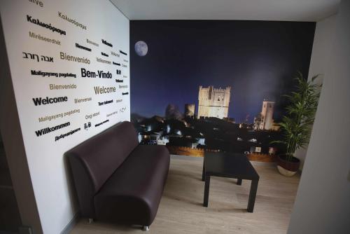a living room with a chair and a wall with a sign at Camoes StudioGeral in Bragança